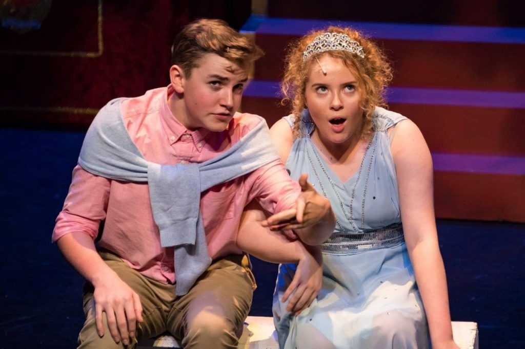 King's InterHigh pupil & musical actor, Daniel Wilmott, acting on stage with a girl in a blue dress & tiara.