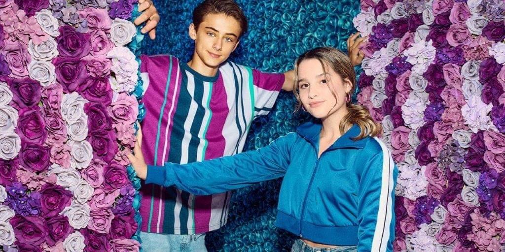 King's InterHigh pupil, & actor, William Franklyn-Miller, pictured in front of a pink and blue floral backdrop with his fellow actress.